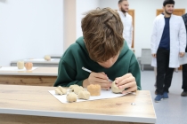 Школьник лепит из пластилина макет зуба